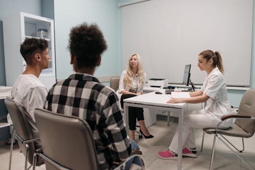 Doctors talking with patients during a medical appointment in a clinic office setting.